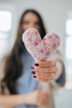 Yumuşak bir kalp şeklinde tutan eller