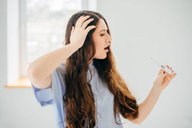 Ateşini ölçen genç bir kadın. Yakın çekim.