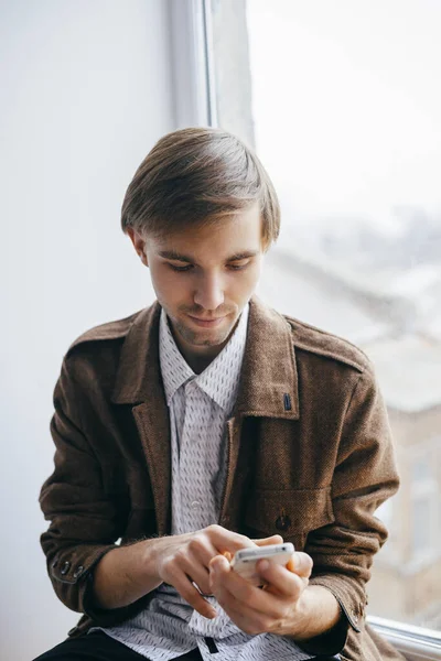 Young man dials number on mobile phone