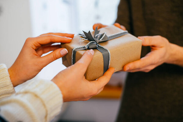 young woman gives a gift in a box