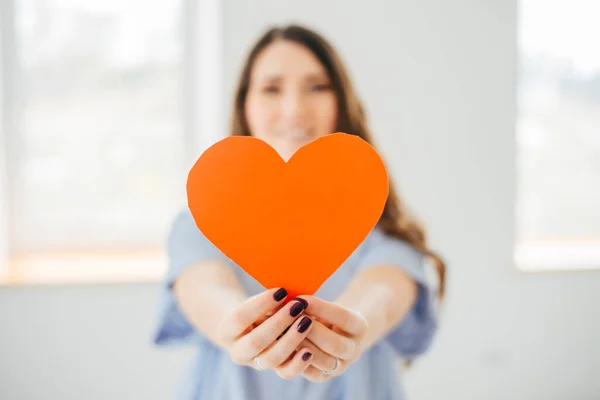 Una Giovane Donna Stende Cuore Carta Costruzione Tagliato Vicino Alla — Foto Stock