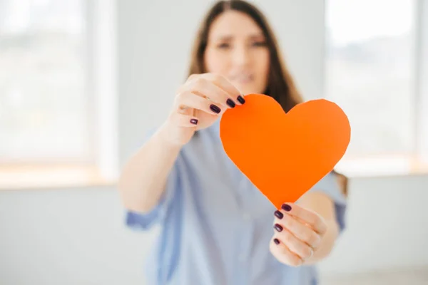 Una Mujer Joven Sostiene Corazón Papel Construcción Cortado Cerca Ventana —  Fotos de Stock