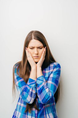 Beyaz bir arka planda üzgün bir genç kız.