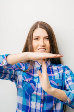 Beyaz arka planda genç kız mola gösteriyor