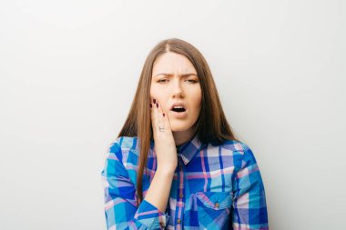 Beyaz bir arka planda genç bir kız diş ağrısı