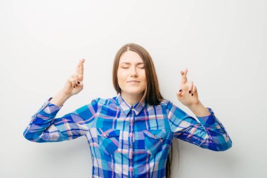 Beyaz bir arka planda genç bir kız şans diledi.