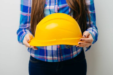 Sarı miğfer tutan mutlu genç kadın