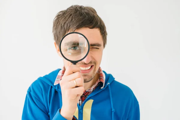 Een Grijze Achtergrond Jongeman Met Een Vergrootglas — Stockfoto