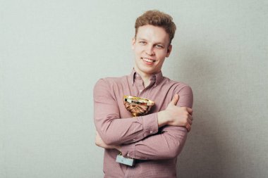 Genç adam kazandı ve kupayı elinde tutuyor.