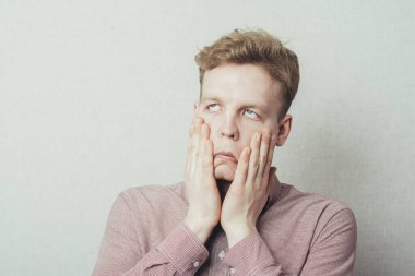 Elleri yüzü asık genç bir adam.