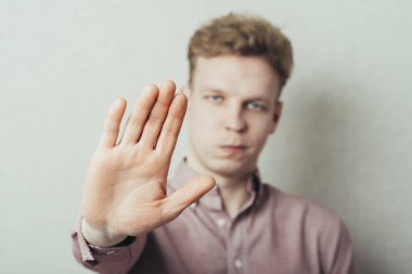 Genç bir adam elleriyle durduruyor.