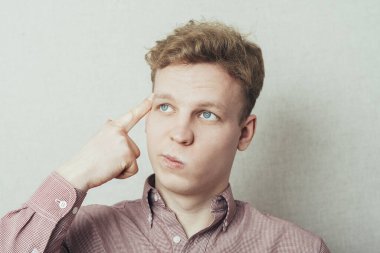 Genç adam parmağını şakağına koyduğunu sanıyor.