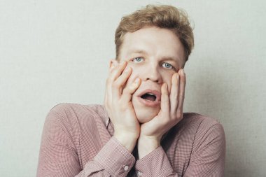 Delikanlı şokta, elleri yüzlerinde.