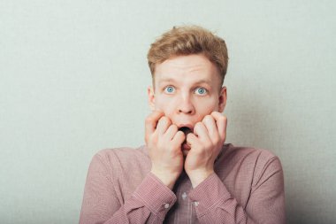 Duyarlı bir adam elleriyle ağzını kapalı tutar.