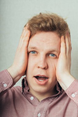 Öfkeli genç adamlar ellerini tutuyorlar.