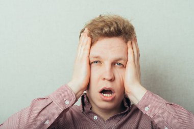 Öfkeli genç adamlar ellerini tutuyorlar.