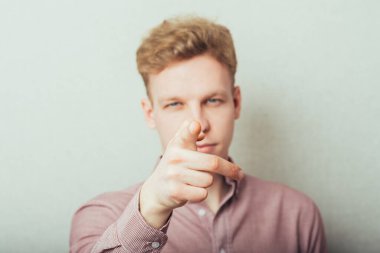 Genç adam, parmağıyla birini işaret ediyor.