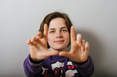 Kız fotoğraf için çerçeve yapıyor.