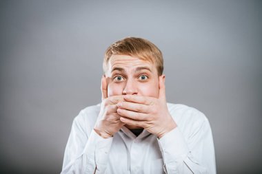 Genç, korkmuş, ağzı kapalı bir yetişkin. 