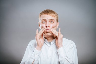 Adam yanaklarını üflemiş, izole edilmiş.