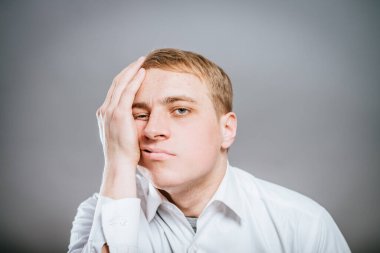 Yorgun ve ilgisiz bir genç adam.