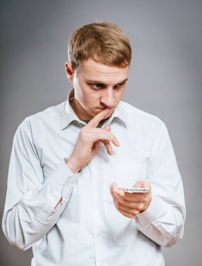 Haberler kötü. Elinde cep telefonu olan, resmi kıyafet giymiş sinirli olgun bir adamın portresi. 