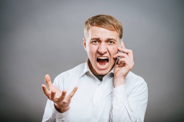Cep telefonuyla bağıran öfkeli bir gencin portresi. 