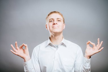 Yakışıklı genç adam meditasyon yapıyor, odaklanmış jest yapıyor..