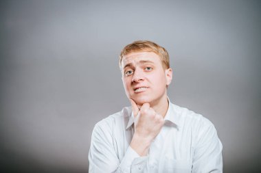 Genç adam düşünüyor. Kafası elinde dinleniyor, kameraya bakıyor. Hareket..