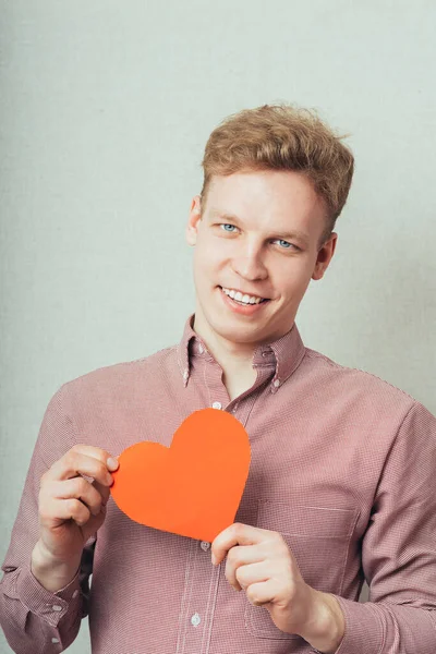 Ung Man Som Håller Ett Rött Hjärta Sina Händer — Stockfoto