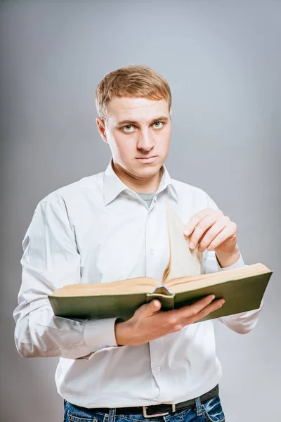 苦思冥想的年轻商人在看书 在灰色背景下 — 图库照片