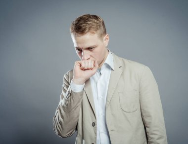 Düşünen adam gri arka planda izole edilmiş. Telif uzayına bakan genç ve düşünceli bir iş adamının yakın plan portresi.. 