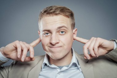 İşadamı kulaklarını kapatıyor. 