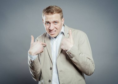 Kendini işaret eden adamın yakın plan portresi. Sanki bana, bana, bana...?