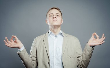 Gri arka planda poz veren genç adam