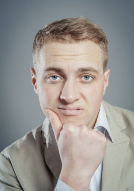 Gri arka planda poz veren genç adam