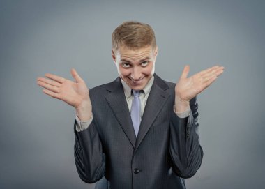 Heyecanlı, gömlekli, iki kolu kameraya doğru uzanmış beyaz tenli bir adam.