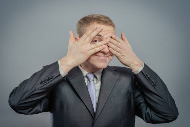 Genç adamın yakın plan portresi, erkek, öğrenci, çocuk, işçi, çalışan, elleri kapalı, göremeyen, saklanan, beyaz arka planda izole edilmiş. Şeytani bir kavram görmüyorum. İnsan duyguları yüz ifadeleri