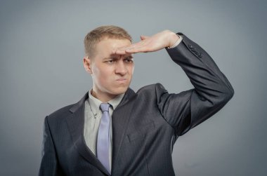 Konsantre olmuş genç işadamı elini alnından tutuyor ve geleceği bekliyor. 