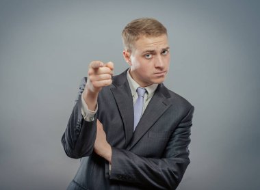 Ciddi bir iş adamı, eli kameraya bakıyor.