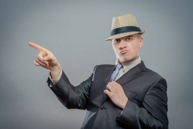 Şapkalı iş adamı parmağıyla işaret ediyor. 