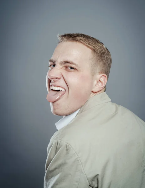 舌で面白い顔をする男の肖像画 — ストック写真