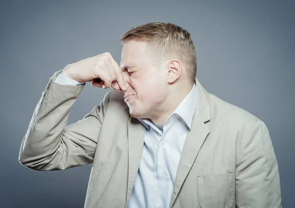 Young Business Man Close Gray Background Grabbing His Nose His — Stock Photo, Image