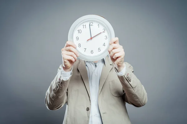 Hombre Cubriendo Cara Con Reloj Pared —  Fotos de Stock