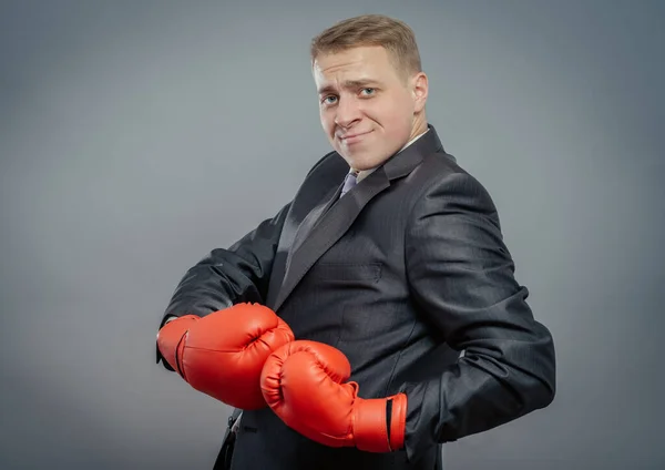 Young man in a suit and boxing gloves, celebrating a win