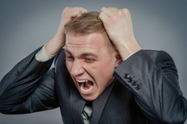 İş adamının portresi ellerini kafaya koyup bağırıyor. Şok, baş ağrısı ve yüksek ateş kavramı