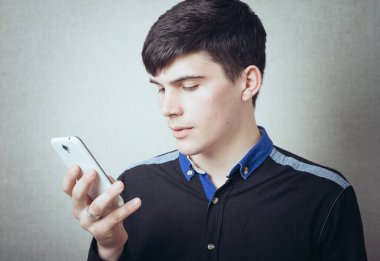 Adam cep telefonundan bir numara çeviriyor.