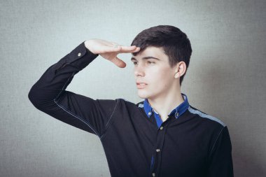 Adam takım elbise giyerken mesafeye bakıyor. 