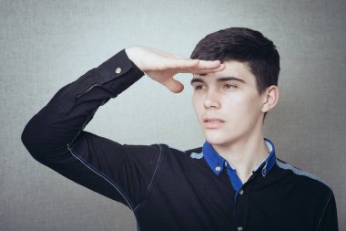 Adam takım elbise giyerken mesafeye bakıyor. 