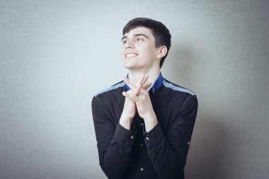 Gri arka planda poz veren genç adam